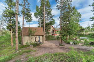 View of side of home featuring a storage shed and a tile roof