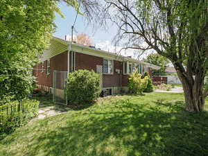 View of side of property featuring brick siding and a wooden deck