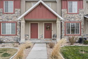 Doorway to property with stone siding and stucco siding