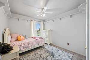 Bedroom with carpet floors, baseboards, a textured ceiling, and ceiling fan