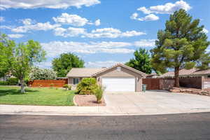 Ranch-style home with a garage, a tiled roof, concrete driveway, and stucco siding