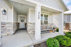 Property entrance with a porch and stone siding