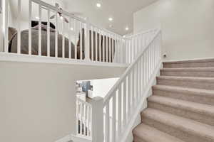 Staircase with recessed lighting and a ceiling fan