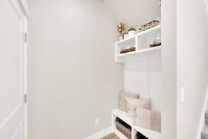 Mudroom with baseboards and lofted ceiling