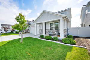 Craftsman-style home with concrete driveway, a porch, a garage, and stone siding