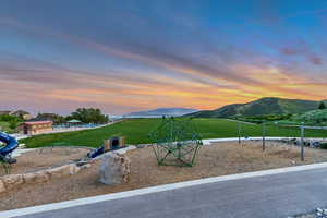View of jungle gym with a mountain view and a yard