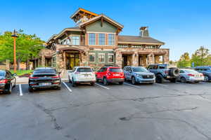 View of front of home with stone siding, uncovered parking, and a chimney