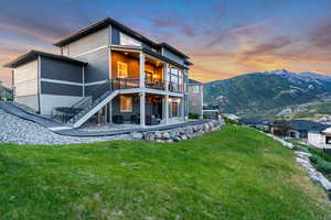 Rear view of property with a patio, stairway, a lawn, outdoor lounge area, and a deck with mountain view