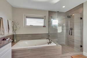 Primary bathroom with jetted tub, walk-in shower, walk-in closet to the right of the shower