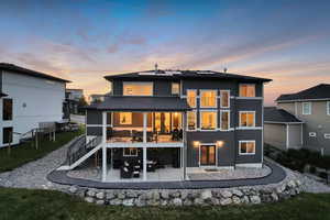 Rear view of property featuring a patio, roof mounted solar panels.