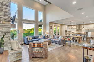 Living area featuring light wood-style floors, recessed lighting, and a high ceiling