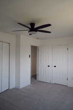 Unfurnished bedroom with carpet floors, baseboards, ceiling fan, and a closet