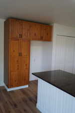 Kitchen featuring dark wood-style floors, brown cabinetry, and dark countertops