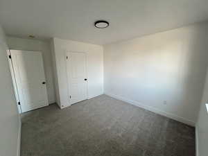 Unfurnished bedroom featuring carpet and baseboards