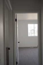 Spare room featuring carpet and baseboards