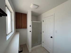 Washroom with light tile patterned flooring and baseboards