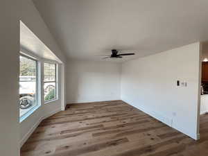 Unfurnished room featuring a ceiling fan, wood finished floors, and baseboards