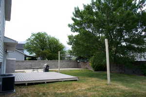 View of yard with central air condition unit and a wooden deck