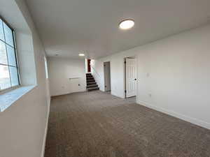 Spare room with baseboards, carpet flooring, and stairway