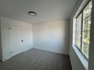Empty room with plenty of natural light, carpet, and baseboards