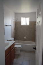 Full bath featuring vanity, toilet, tile patterned flooring, and shower / bathtub combination