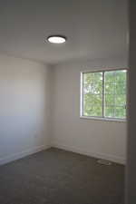 Spare room with carpet and baseboards