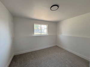 Spare room featuring carpet and baseboards