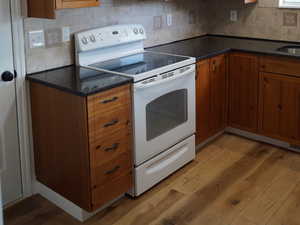 Kitchen with white appliances, brown cabinets, and light wood finished floors