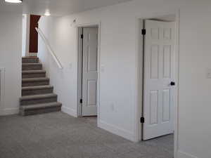 Below grade area with carpet, stairway, and baseboards