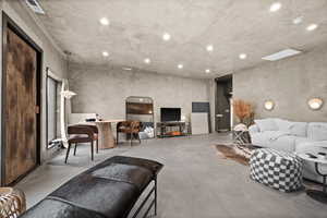 Living area featuring finished concrete floors and recessed lighting