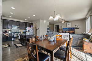 Dining area featuring dark wood-style floors, ceiling fan, recessed lighting, and a chandelier