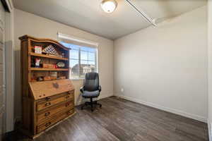 Office area with dark wood-type flooring and baseboards