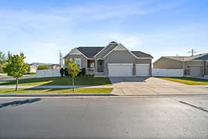 View of front facade featuring an attached garage, stone siding, concrete driveway, and stucco siding