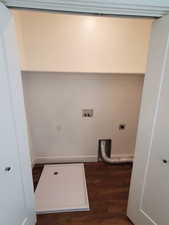 Washroom with hookup for an electric dryer, wood finished floors, baseboards, and washer hookup