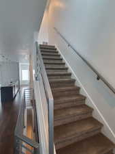Stairway featuring wood finished floors