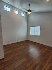 Unfurnished room with dark wood finished floors, baseboards, and ceiling fan