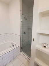 Bathroom with a stall shower, a garden tub, and tile patterned flooring