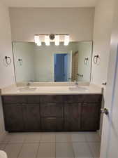 Full bath with double vanity and tile patterned floors