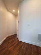 Empty room featuring baseboards, dark wood-type flooring, recessed lighting, and a smoke detector