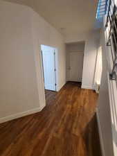 Hallway featuring baseboards and dark wood finished floors