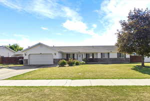 Ranch-style house with stone siding, driveway, and a garage