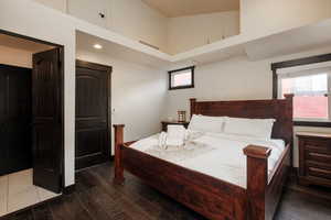 Bedroom featuring dark wood finished floors and a high ceiling