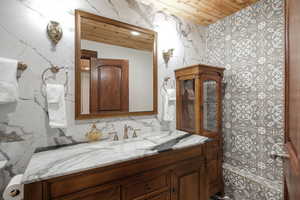 Bathroom featuring wooden ceiling, vanity, and toilet