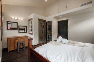Bedroom with dark wood-style floors, recessed lighting, and a high ceiling