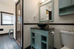 Bathroom with vanity, toilet, and wood finished floors