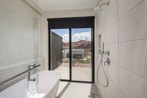 Bathroom featuring a freestanding tub, a mountain view, tile patterned flooring, a shower, and tile walls