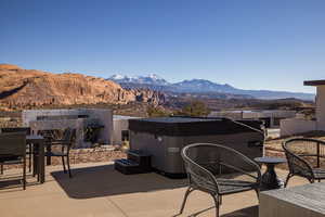 View of patio / terrace featuring a hot tub and a mountain view