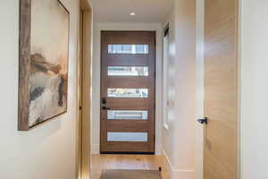 Entryway with wood finished floors and recessed lighting