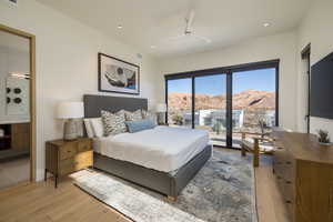 Bedroom featuring access to exterior, a ceiling fan, light wood-style flooring, recessed lighting, and ensuite bathroom