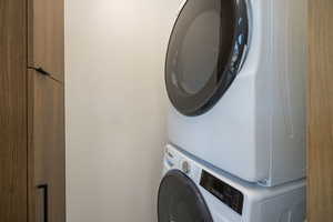 Laundry room featuring stacked washing machine and dryer